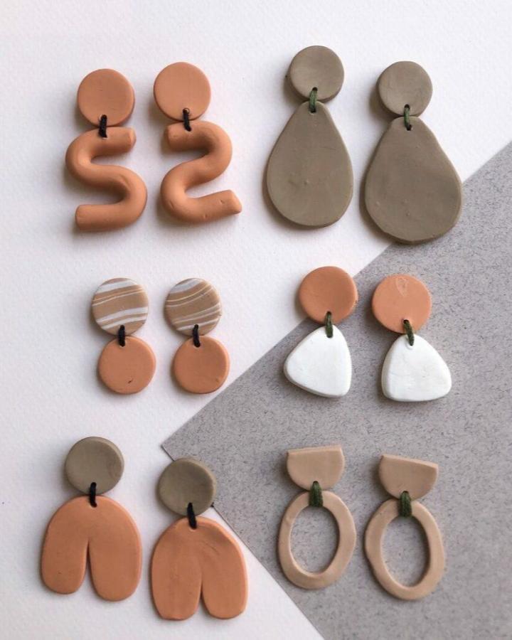 Terracotta and beige abstract polymer clay earrings in minimalist playful shapes from xoxo jackie. Earthy toned handmade accessories on white and grey background.