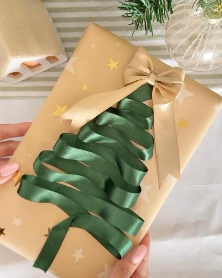 Green satin ribbon Christmas tree on beige starry gift wrap by @allseasongreetings ribbon crafts for adults with elegant bow topper.