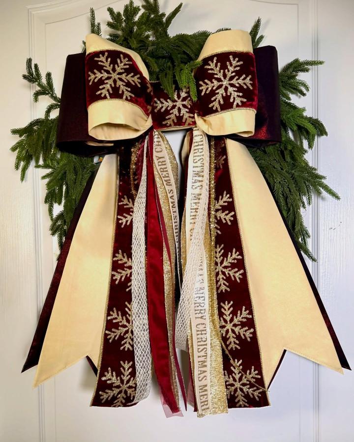 Lush burgundy and ivory velvet ribbon bow with gold snowflakes on greenery wreath by @the_lucky_toadstool, layered festive style