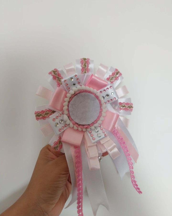 Pink and white layered ribbon rosette with rhinestones and pom-poms from @agoodpotato.pop. Elegant handmade decorative ribbon craft.