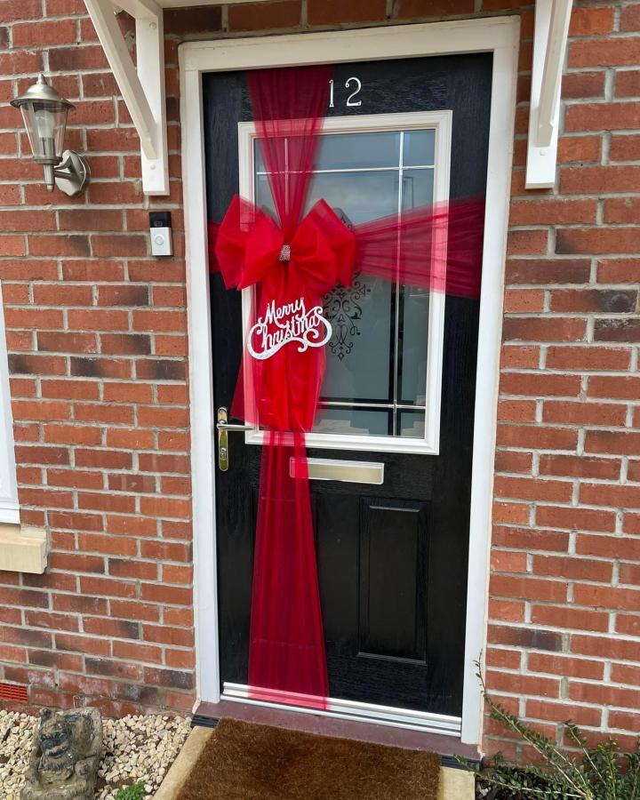 Red sheer ribbon wrapped door decoration with large bow and white Merry Christmas sign by @cwright903 for ribbon crafts for adults festive entryway.
