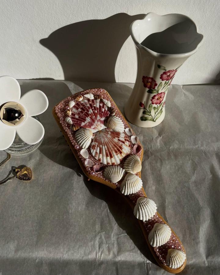 Seashell decorated wooden hand mirror with pink beads from @muse_and_made featuring natural scallop shells perfect for seashell crafts for adults.