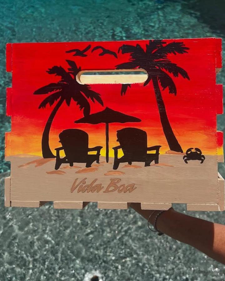 Sunset red and orange painted wooden crate with black palm tree silhouettes and beach scene by @savthegemgenie perfect for summer craft ideas.