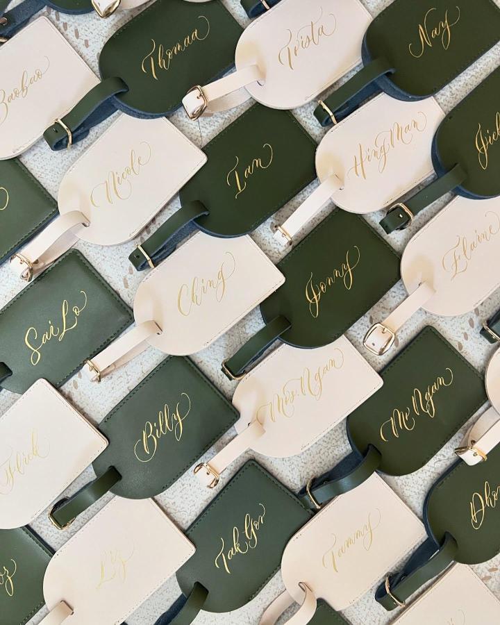 olive green and cream leather luggage tags from @thesilverlininghk with gold calligraphy perfect wedding favor ideas elegant and personalized design