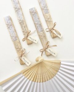 Beige lace detailed wooden hand fans by @byfeyzagoncal for wedding favor ideas, tied with satin ribbon and tags.
