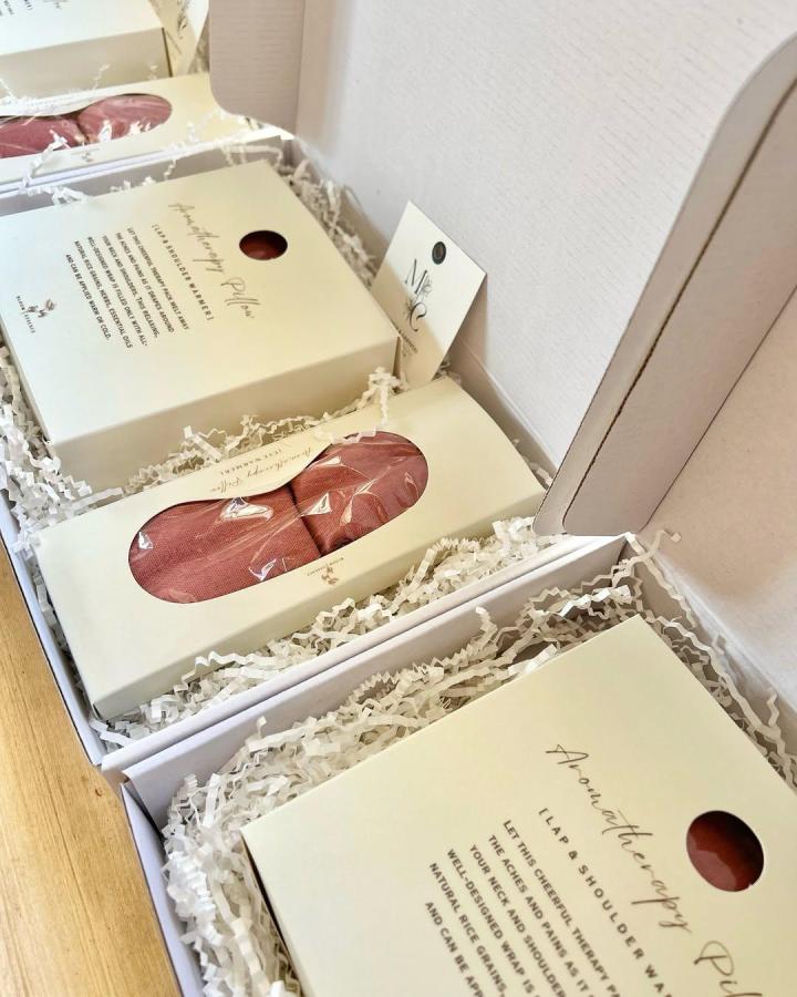 Rust colored aromatherapy pullover wraps in cream boxes with shredded paper packaging from @bloomessence.ph wedding favor ideas cozy and elegant.