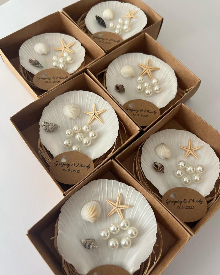 White scallop shells with pearls and starfish in kraft favor boxes by @pearlsavon_favors wedding favor ideas beach decor keepsakes