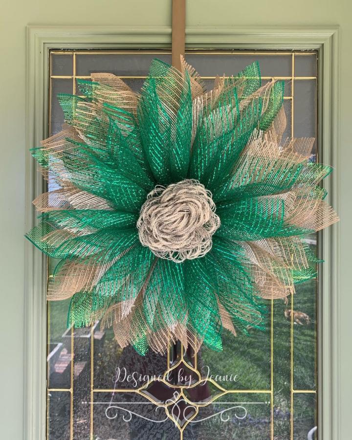 Green and natural burlap wreath with curled burlap center from @designedbyjeanie. Rustic textured flower shape with vibrant mesh layers.