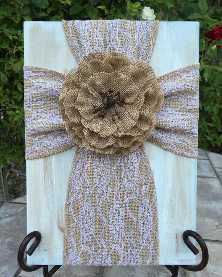 Natural burlap flower with white lace overlay on wooden stand from @sweetsunshinedecor showcasing rustic handmade craft detail.