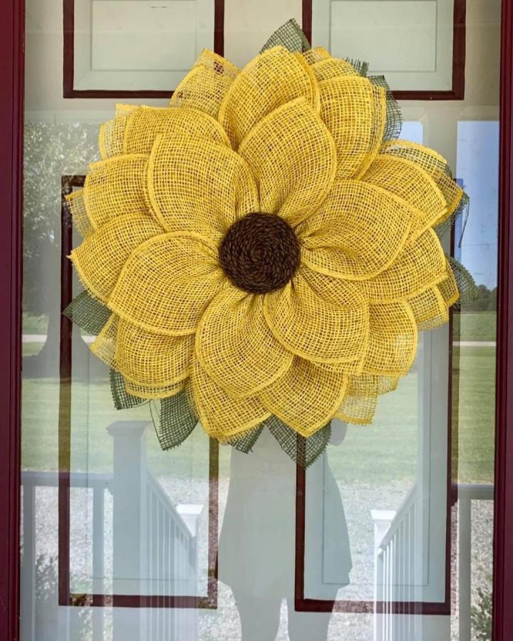 Yellow and green burlap sunflower wreath on front door from @shabby_sunshine. Large layered petals with rustic texture create a bright, handmade look.