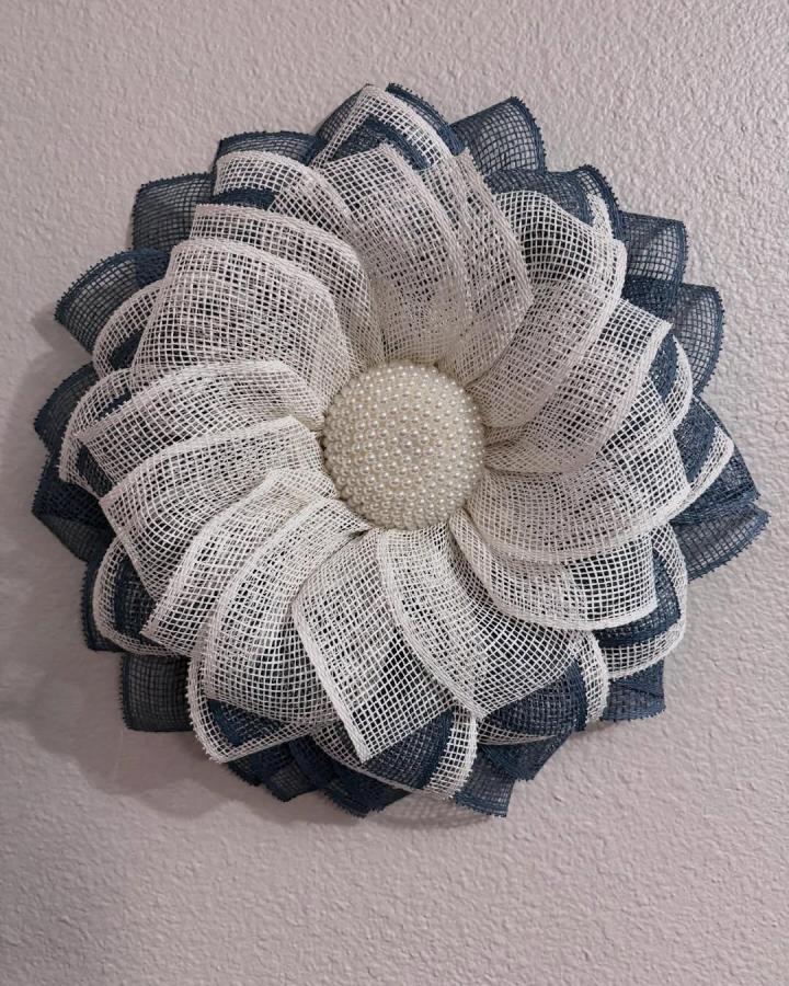 Navy and white burlap floral craft from @meganmakeswreaths featuring pearl bead center with layered textured loops.