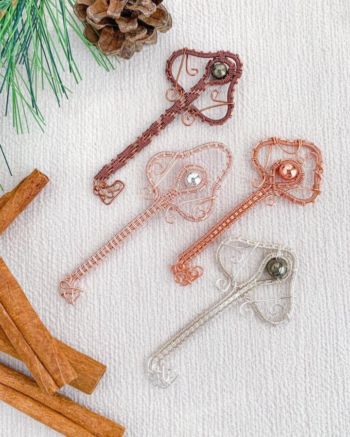 Copper wire crafts featuring intricately wrapped skeleton key bookmarks by @therustailor with elegant bead details and warm tones.