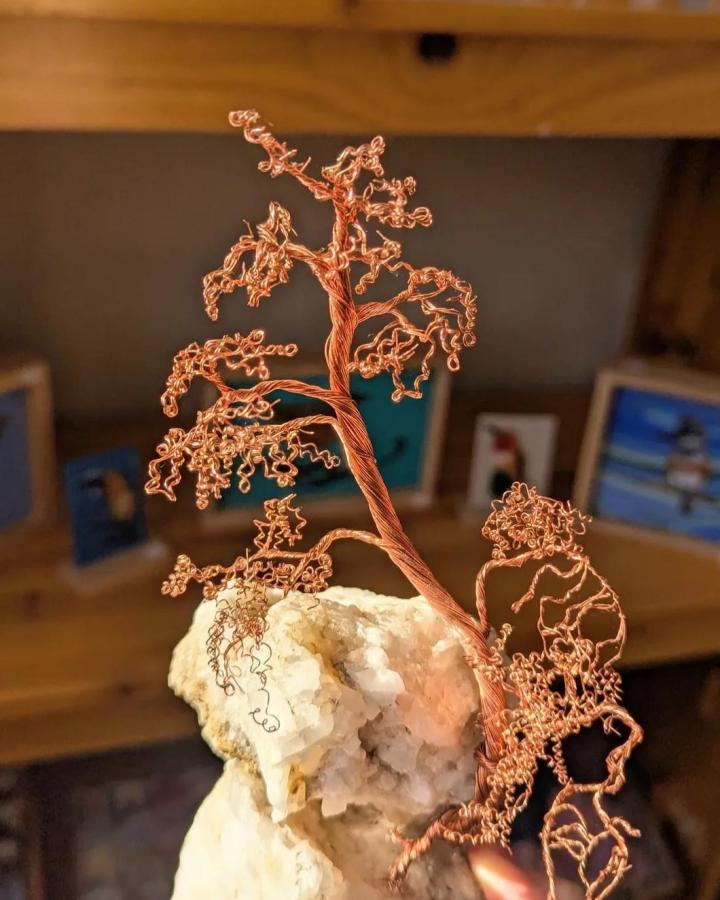 Copper wire twisted into a delicate tree sculpture on white stone base from @wire_arborist detailed and artistic wire bending design.
