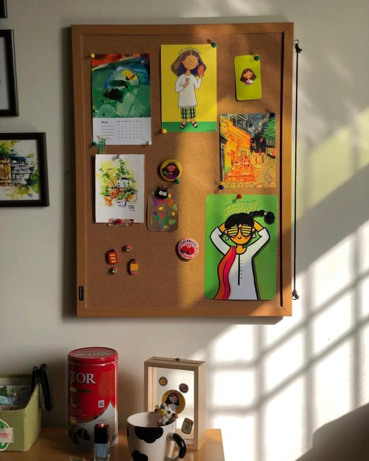 Bright colorful cork board art display from @krapbook featuring playful prints and quirky magnets in natural light ambiance.
