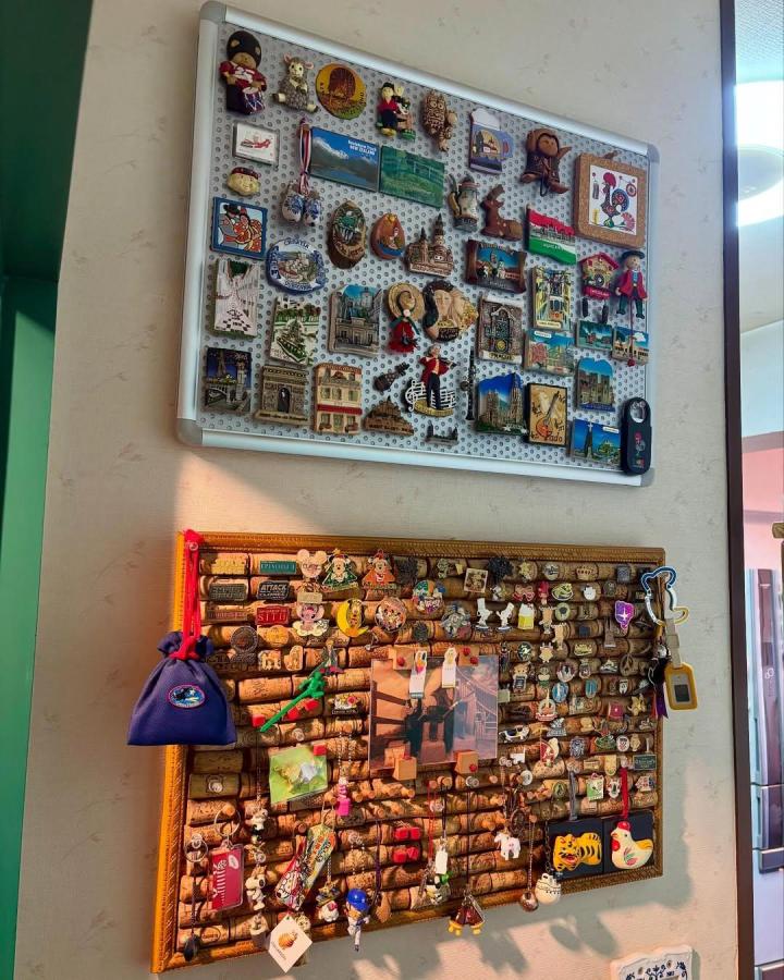 Natural wine cork pin board with colorful souvenirs and keychains from @kennoji45 displaying a creative keepsake collection.