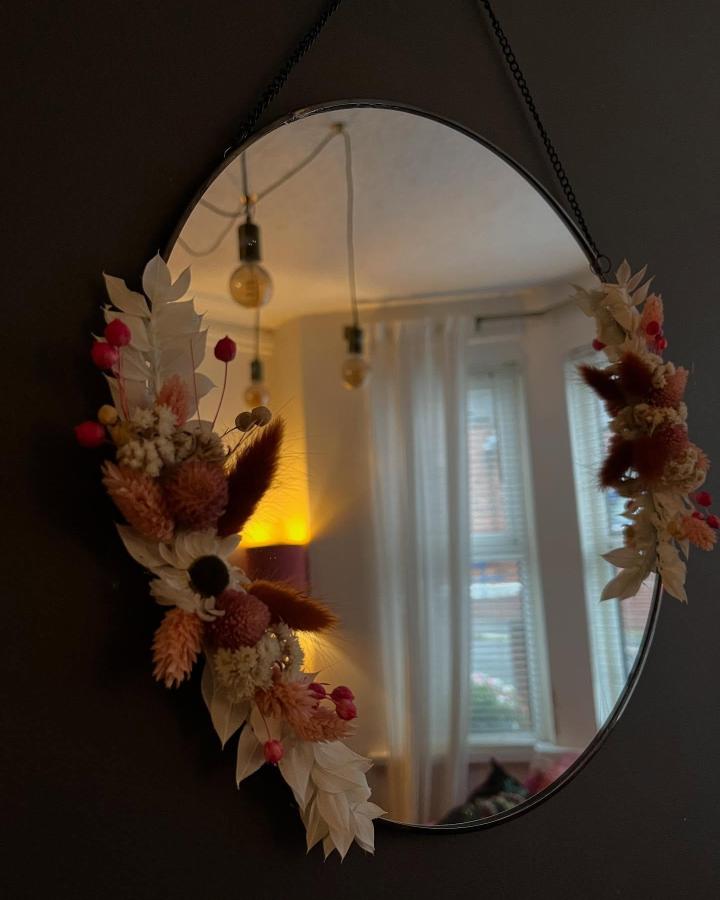 Soft pink and cream dried flower mirror frame from @cut_and_dried_flowers. Rustic botanical wall decoration with natural textures.