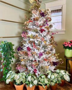 White artificial Christmas tree decorated with colorful dried flower clusters by @chicagogardener. Vibrant rustic holiday craft with natural textures.
