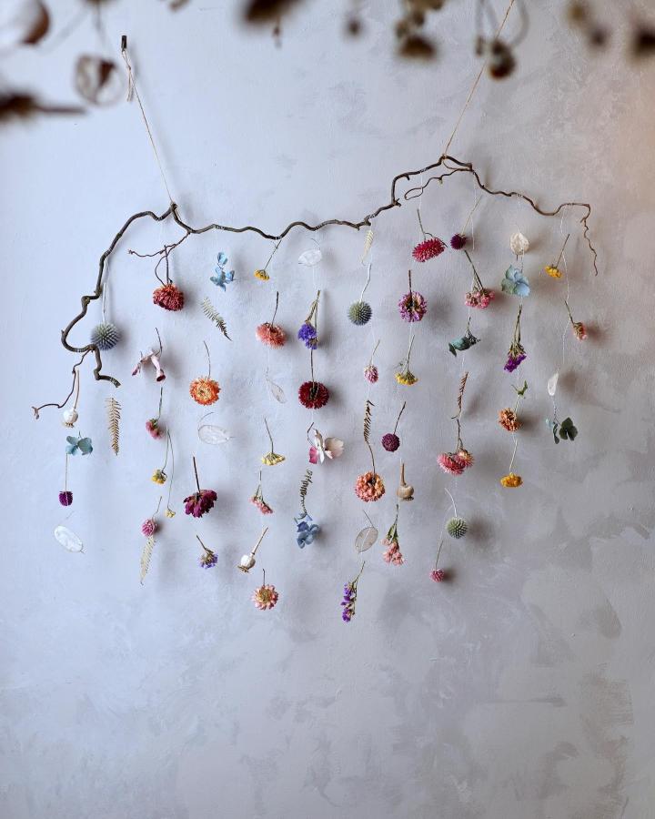 Natural branch with delicate hanging dried flowers mobile from @harebellandbee. An airy, colorful display of dried flower crafts.