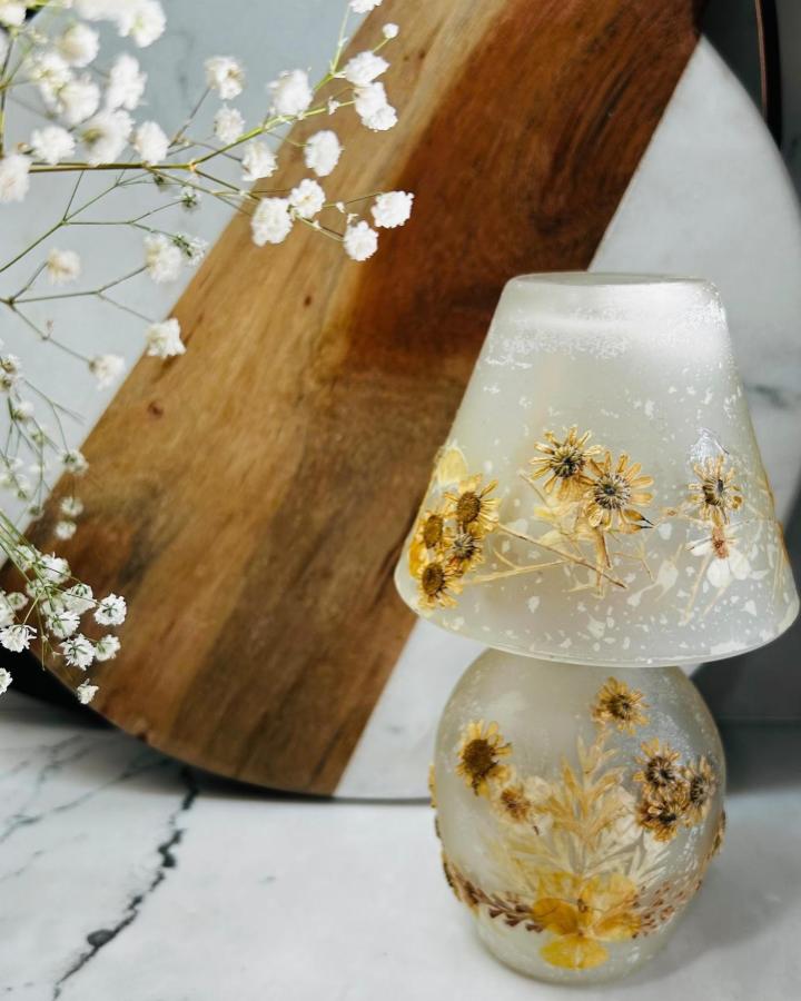 Yellow dried flowers embedded frosted glass lamp from @yours.truly_home. Delicate floral decor with cozy natural vibe.