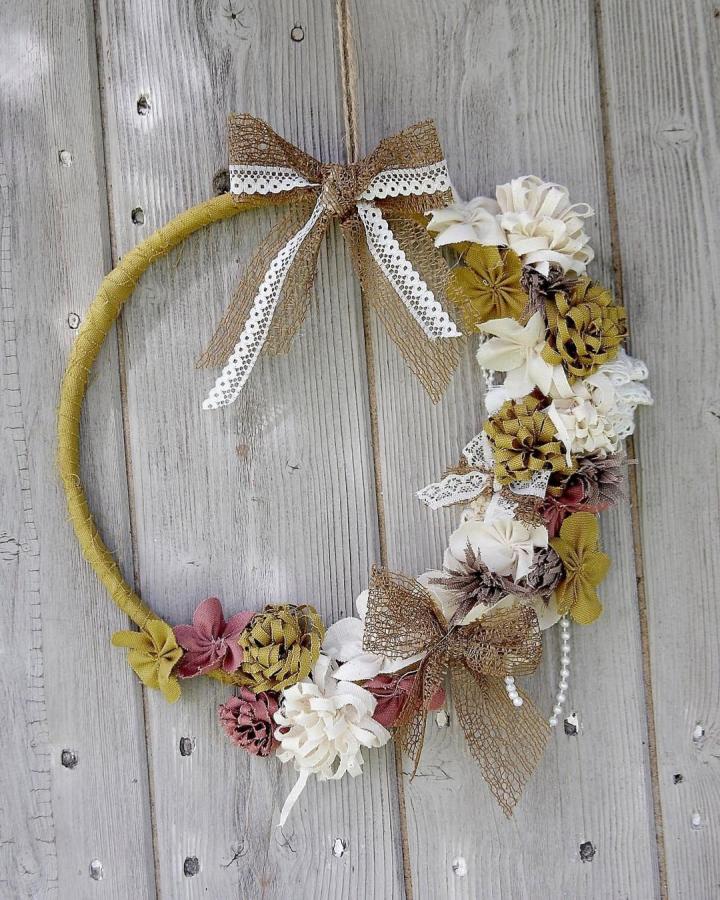 Rustic mustard and cream fabric flower garland wreath from @halfyardsewingclub with burlap bows and lace on wood background fabric flower ideas.