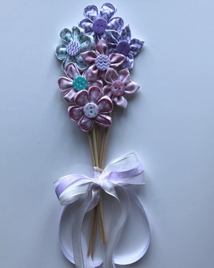 Pastel satin and patterned cotton flower bouquet with button centers on wooden stems by @elisabau showcasing a handmade crafty charm