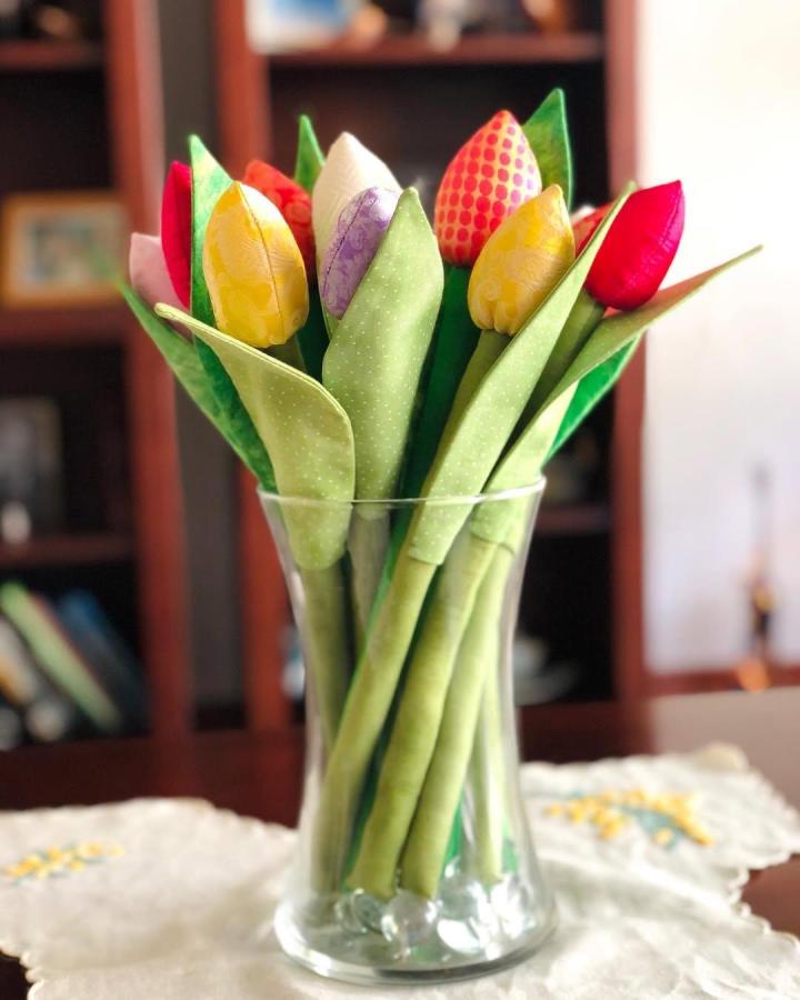 Bright colorful sewn tulip bouquet in glass vase by @gypsytailor showing handcrafted textile petals and green fabric leaves.