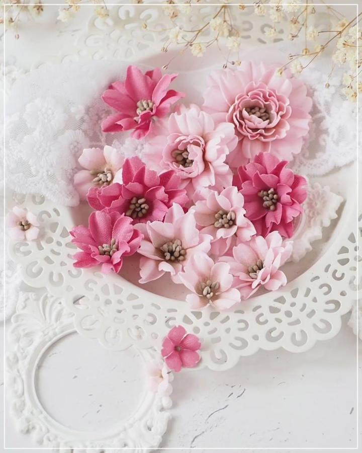 Pink and dusty rose layered fabric flowers on white lace plate from @gosia.metryka. Soft delicate fabric flower ideas with bead centers.