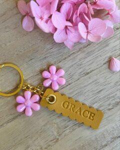 Mustard yellow scalloped faux leather keychain with pink flower charms by @at_home_with_gracey. Personalized and playful accessory.