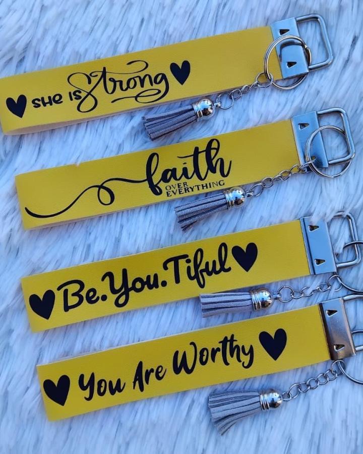 Bright yellow wrist keychains with inspirational text and gray tassels from @canicavanlog. Cheerful upbeat accessory idea.
