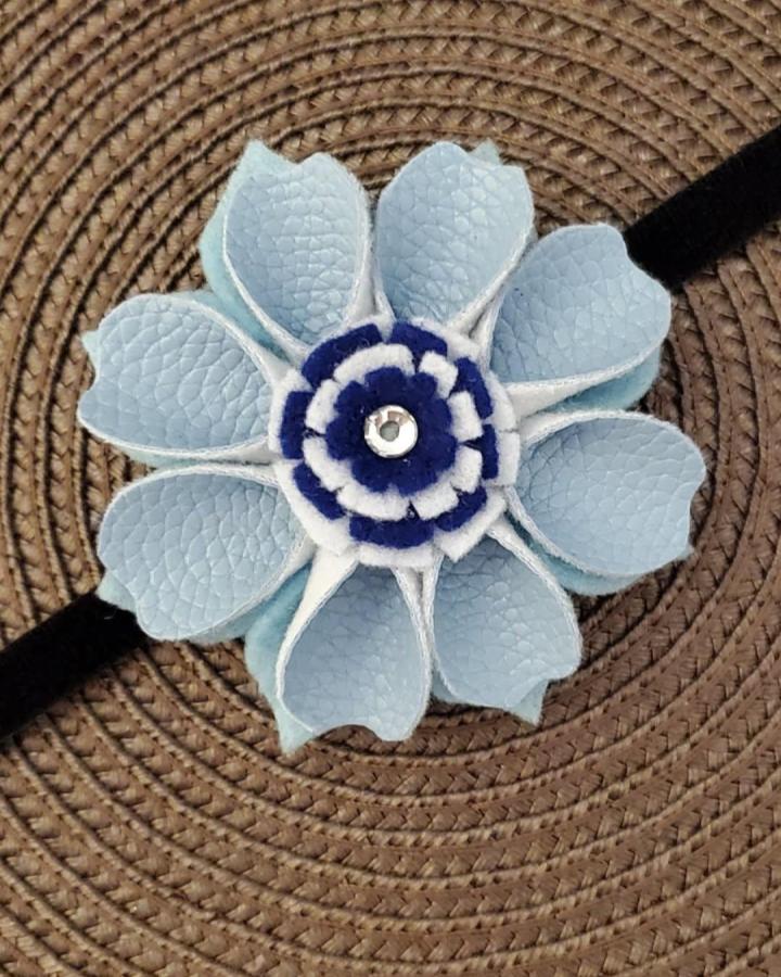 Light blue textured flower headband from @jennysworldoffelt featuring layered soft faux leather petals and felt center jewel detail.