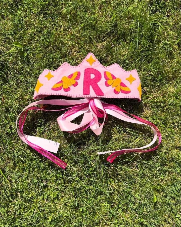Pink felt crown with butterfly designs and ribbon ties from @thatautistartist. Felt crafts for adults featuring personalized detail and bright colors.