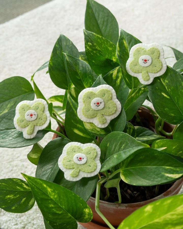 Green and white felt clover plant markers with happy faces by @whostolemypencils adding playful charm to houseplants.