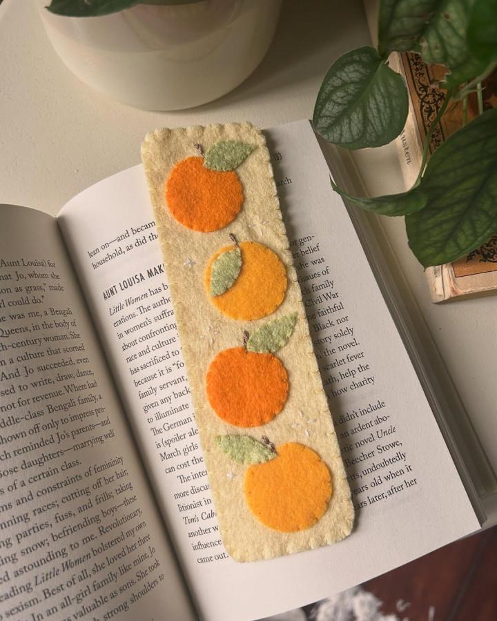 Orange and green felt bookmark on cream base from @papergirlgoods. Handmade fruit motif perfect for felt crafts for adults reading accessories.