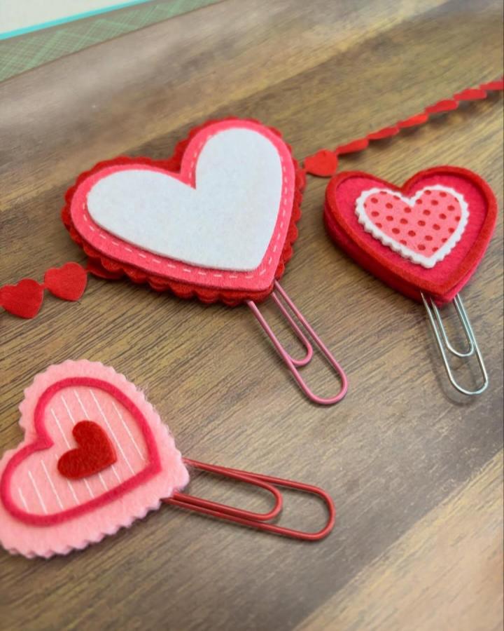 Red and pink layered heart-shaped felt paperclip holders from @amandajane_craftee. Handmade with scalloped edges and stitched details.