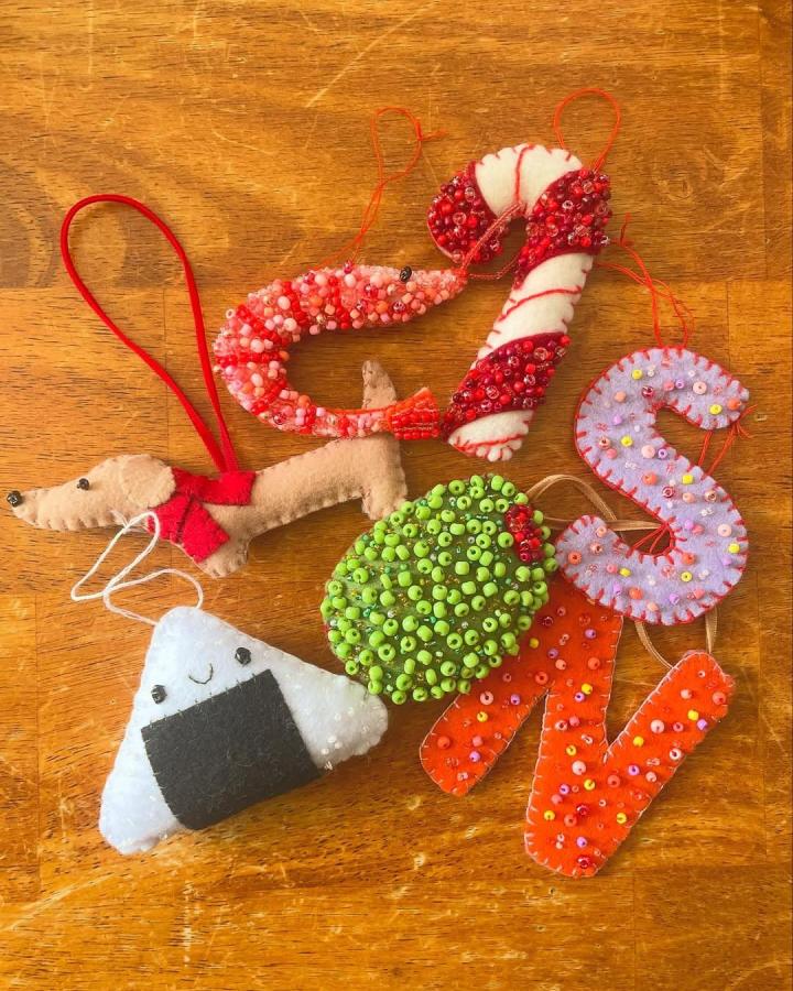 Red, green, and pastel beaded felt ornaments from @sarah.n.designs for felt crafts for adults with detailed beadwork and charming shapes.