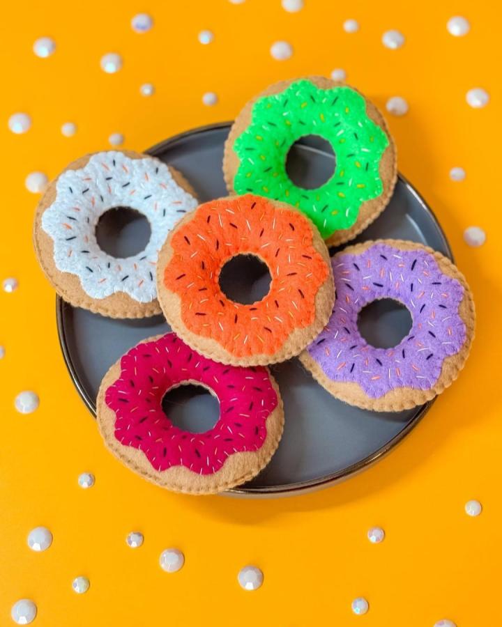 Colorful felt donut crafts with stitched sprinkles from @kn0tty_by_nature featuring felt crafts for adults in bright playful designs.