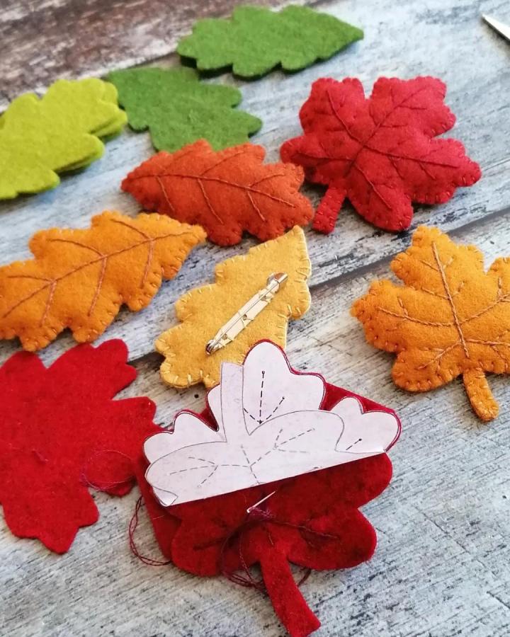Vibrant autumn felt leaf brooch ornaments by @dusicrafts showcasing warm colors and stitched details perfect for felt ornament ideas.