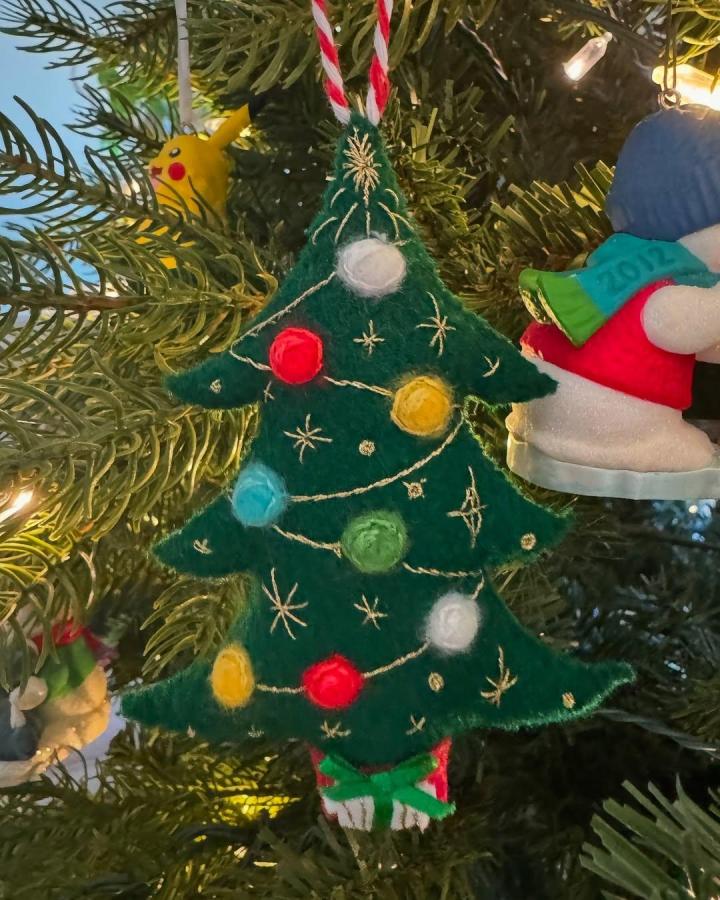 Green felt Christmas tree ornament with colorful felt baubles and embroidered gold stars by @hannah.mae.craft. Handmade holiday decoration.