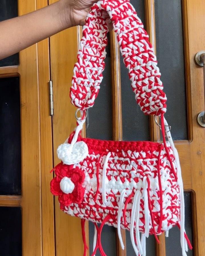 Red and white chunky crochet bag with flower detail from @knotique22 showcasing thick yarn and bold color contrast.