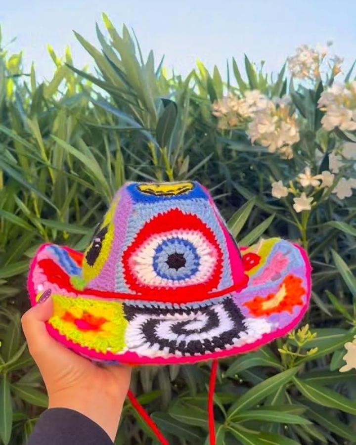 Bright and colorful crochet hat with unique patchwork and spiral motifs by @stitchinwithliz. Funky handmade craft piece.