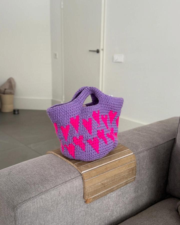 Purple and pink crochet tote with heart motifs by @studio_zo.nl showing funky crochet pattern ideas and chunky yarn texture.