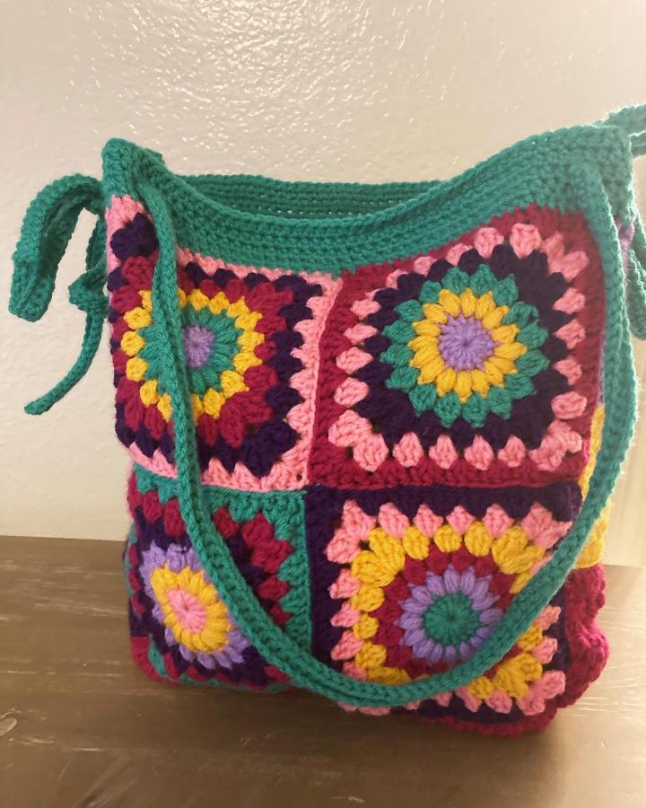 Colorful granny square crochet bag with teal strap by @chunkycatcrafts.atx Bright handmade accessory with retro charm and mixed yarn textures.
