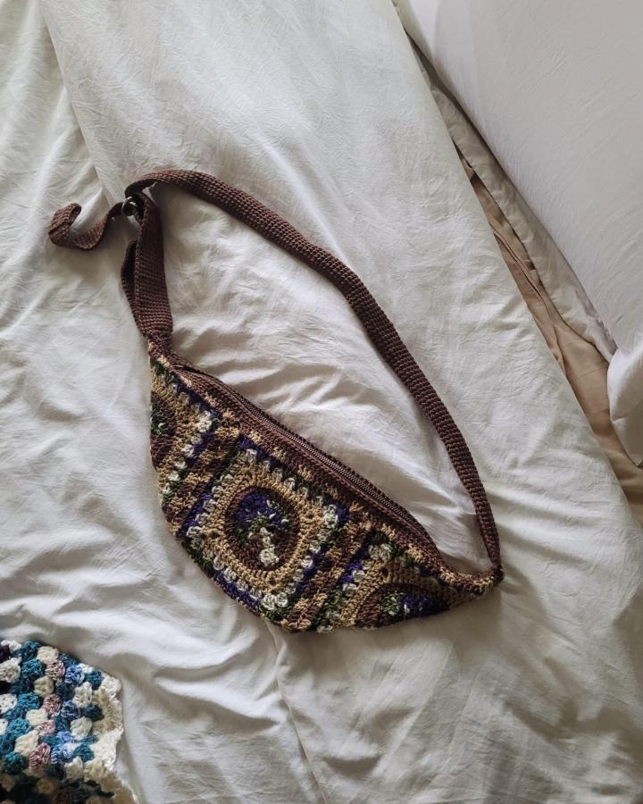 Brown lavender and green granny square crochet fanny pack by @lucy.loops.endlessly on white bedding funky handmade bag accessory