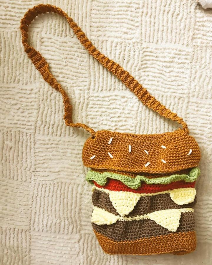 Funky brown and colorful crochet bag from @smokehousecrochet shaped like a playful sandwich with textured layers.