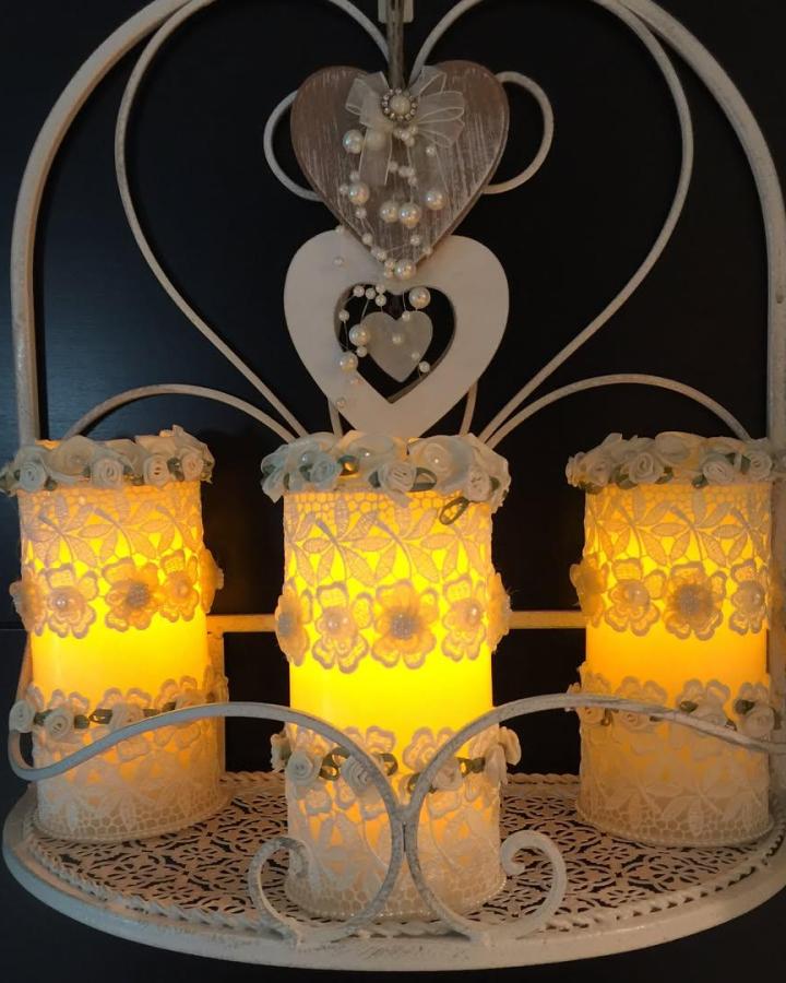 White lace decorated flameless candles on a shabby chic metal shelf from @myshabbychicprojects. Warm floral lace candle holders with delicate fabric rose accents.