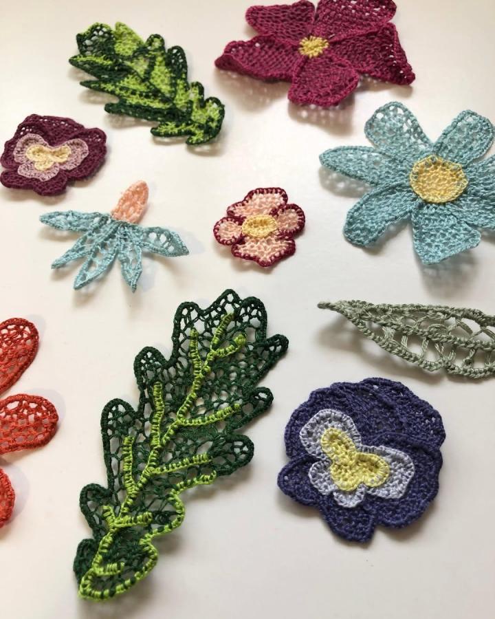 Colorful delicate needle lace flowers and leaves from @mcreativej. Handmade textile floral creations showing intricate stitching and vibrant threadwork.