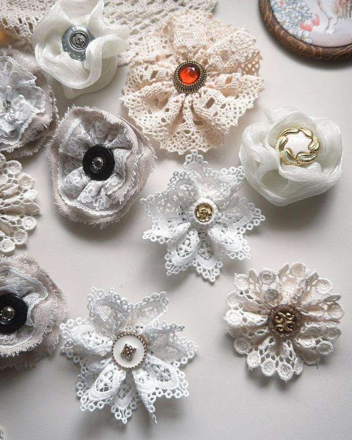 White and beige lace brooches with vintage button centers by @battypei showcasing lace crafts for adults detail and texture.