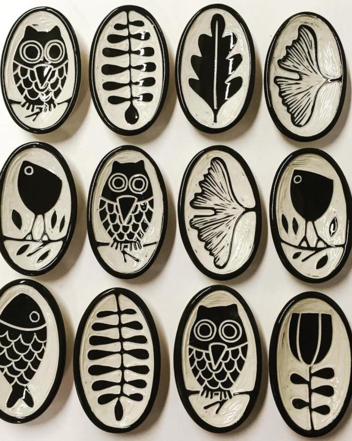 Black and white ceramic tile set from Jennifer Falter featuring owl and botanical designs in bold graphic style.
