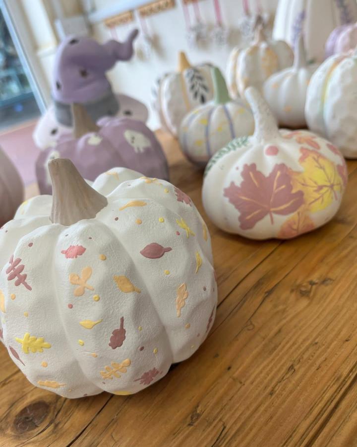 White mini pumpkins painted with delicate autumn leaves by @pitterpottertenburywells. Cozy fall-themed handpainted decoration.