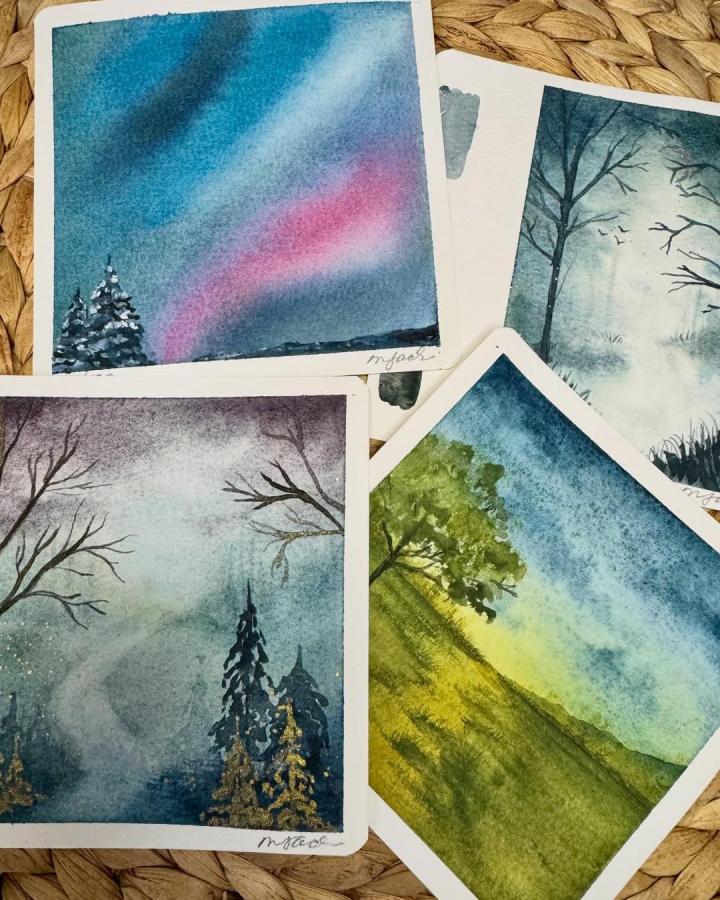 Soft watercolor landscape paintings by @what.melissa.creates showcasing trees and sky in muted blues and greens, perfect painting crafts for adults.